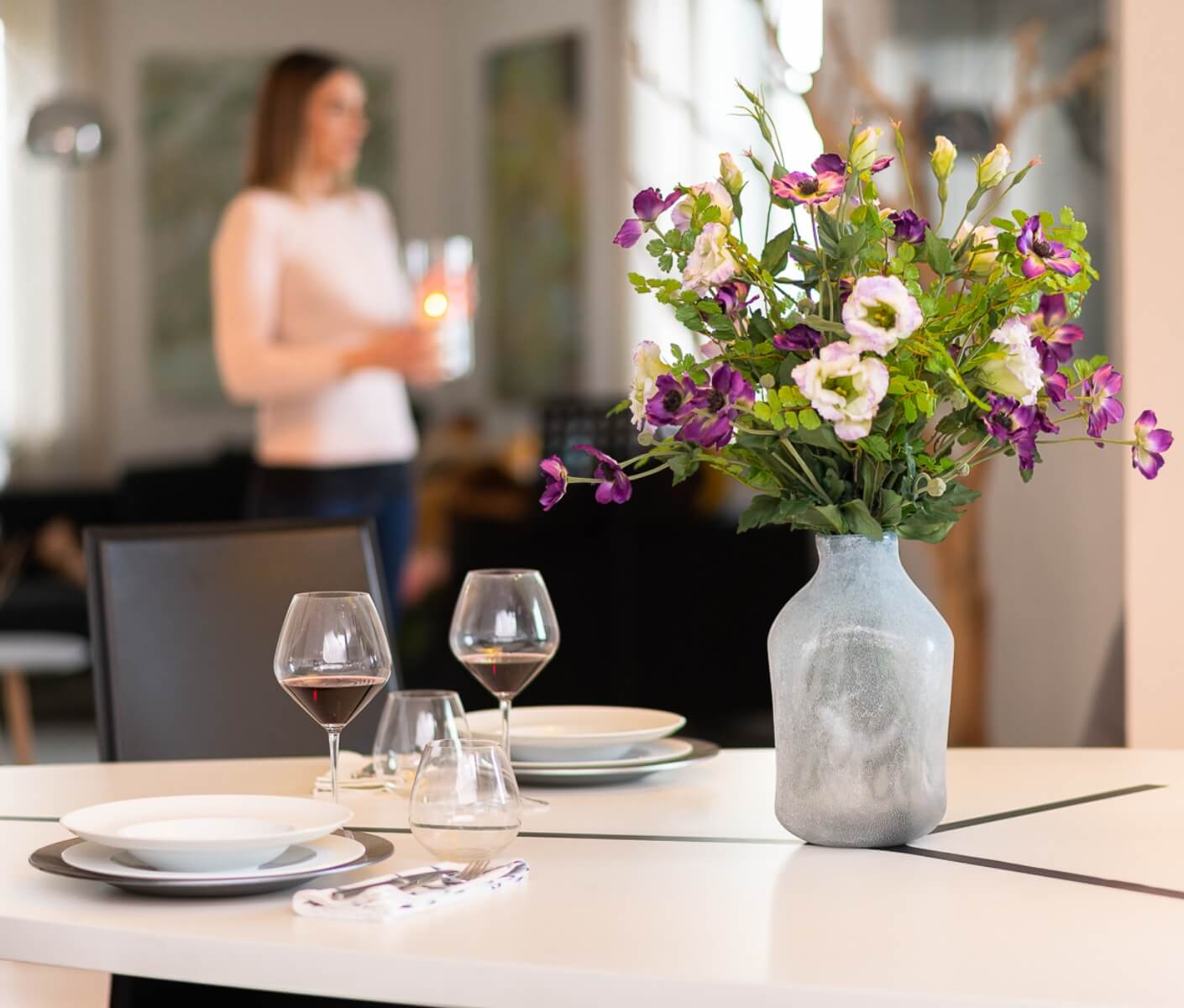 piatti e bicchieri su un tavolo con un vaso pieno di fiori